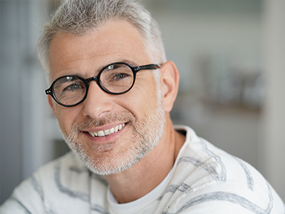 The image shows a man with glasses smiling at the camera, with two identical photos placed side by side on either side of him.
