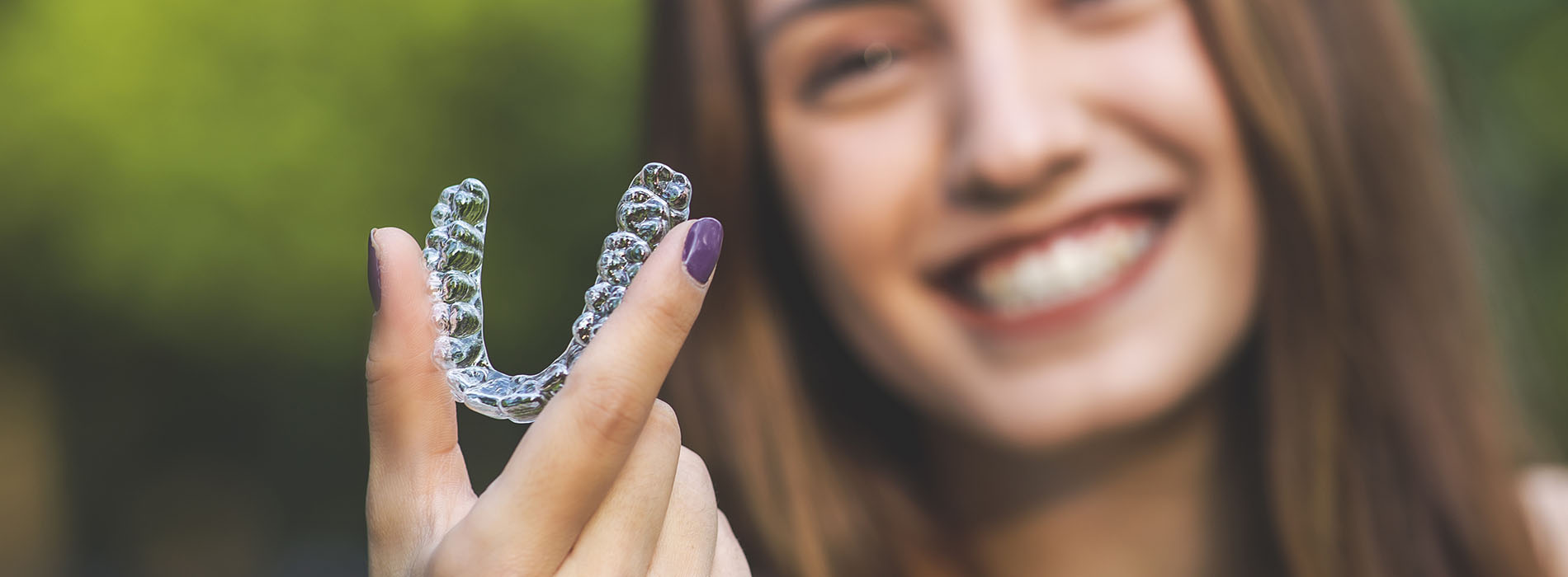 The image shows a person holding a plastic letter  V  with their hand.